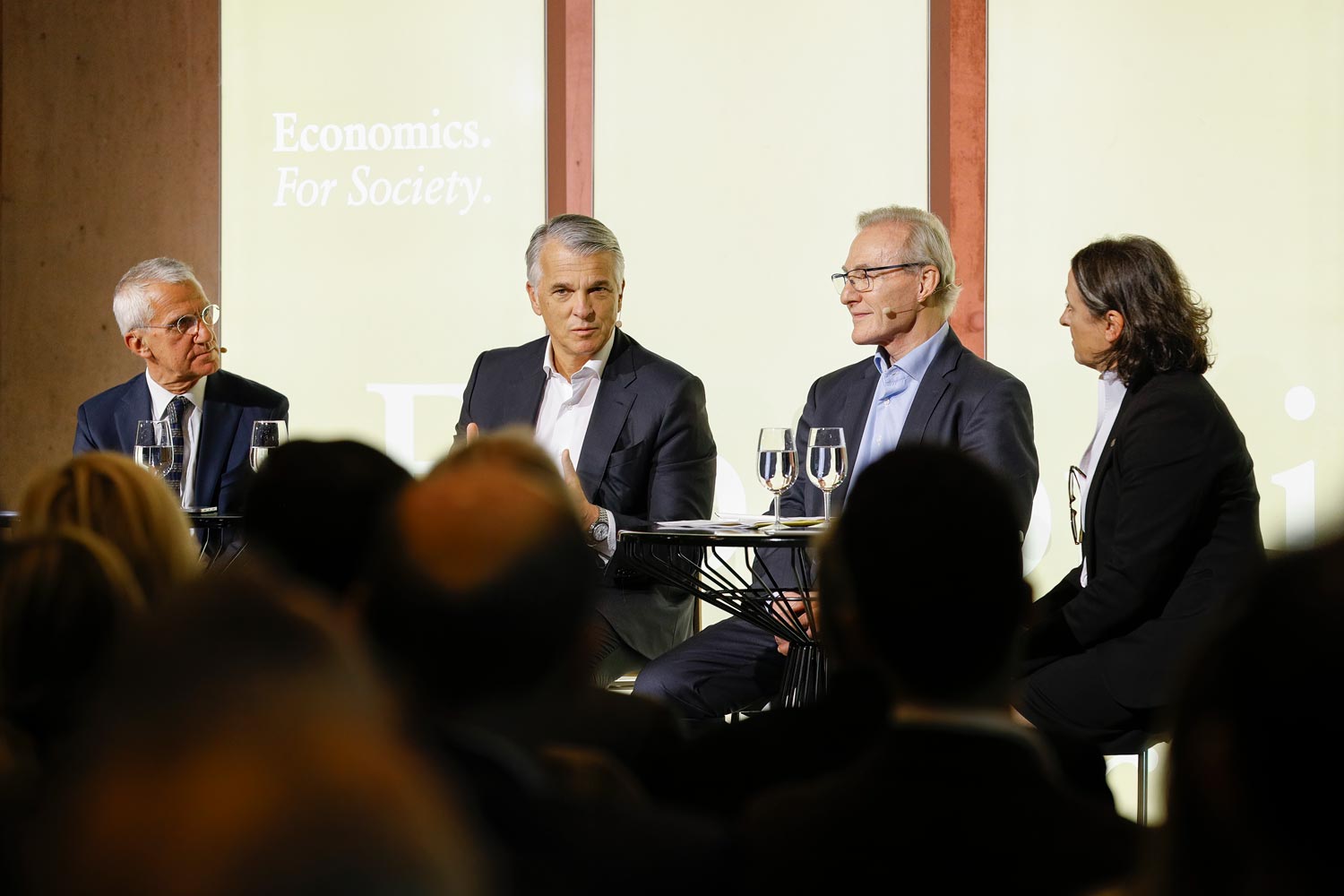 The panel discussion brought together Luigi Guiso (EIEF), Sergio P. Ermotti (UBS), and Ernst Fehr (University of Zurich), with USI Rector Luisa Lambertini as moderator.